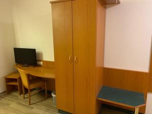 a room with a desk with a computer and a cabinet at Hotel Gaststätte Weinbrücke in Kulmbach