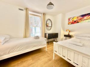 ein Schlafzimmer mit zwei Betten und einem Fenster in der Unterkunft Riverside Apartment at Woodsmill Quay in York