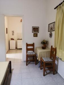 Pokój ze stołem i krzesłami oraz kuchnią w obiekcie Maria's Studios yellow w mieście Afissos