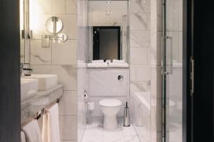 a white bathroom with a toilet and a shower at Casa Hotel in Chesterfield