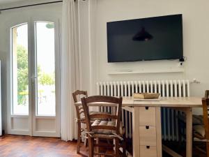 a living room with a table and a television on the wall at Gite Harmonie in Gréoux-les-Bains