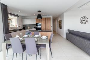 comedor y cocina con mesa y sillas en Seafront Luxury Apartment en St. Paul's Bay