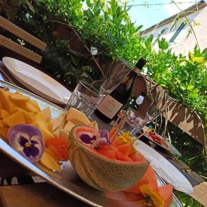 - une assiette de nourriture avec une bouteille de vin et un bol de fruits dans l'établissement Chiaro di Luna - Casa Vacanze, à Rome