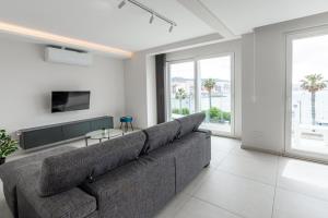 a living room with a large couch and a tv at Seafront Luxury Apartment in St Paul's Bay
