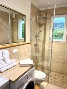 y baño con ducha y lavadora. en Gite Harmonie en Gréoux-les-Bains