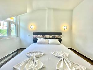 a bedroom with a large white bed with two bows at Bucanero Apartments Budva in Budva