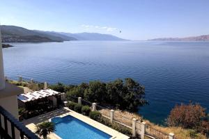a swimming pool next to a large body of water at Großzügiges Appartement direkt am Meer mit eigenem Pool - Povile Suites in Novi Vinodolski