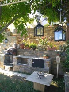 a stone wall with a table in a yard at Evelina - Home with View in Volos