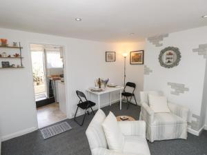 a living room with white furniture and a table and chairs at Castle Cottage in Newport