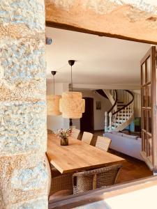 comedor con mesa de madera y pared de piedra en Beautiful stone house with fabulous pool and outdoor kitchen en Auribeau-sur-Siagne