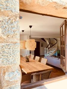 a dining room with a wooden table and a stone wall at Beautiful stone house with fabulous pool and outdoor kitchen in Auribeau-sur-Siagne