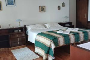 una camera con un letto con una coperta verde e bianca di Brezza Marina - Appartamento in villa fronte mare a Trieste