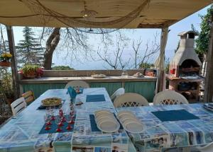 uma mesa com uma toalha de mesa azul num pátio em Brezza Marina - Appartamento in villa fronte mare em Trieste