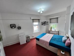 - une chambre avec un lit bleu et 2 fenêtres dans l'établissement Born Park, à Bournemouth