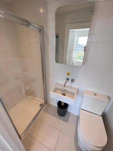 uma casa de banho com um chuveiro, um WC e um lavatório. em Born Park em Bournemouth