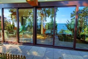 a house with large windows and a view of the ocean at Brezza Marina - Appartamento in villa fronte mare in Trieste