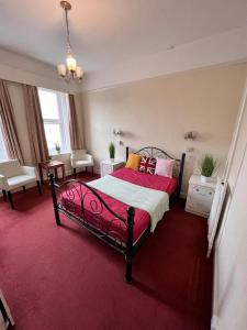 - une chambre avec un lit rouge et un tapis rouge dans l'établissement Born Park, à Bournemouth