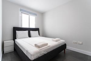 een witte slaapkamer met een bed met twee handdoeken erop bij Apt Fuengirola Old Town by Costarentals - Ref 181 in Fuengirola