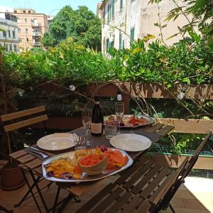a table with two plates of food and a bottle of wine at Chiaro di Luna - Casa Vacanze in Rome