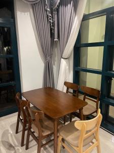 drewniany stół i krzesła w pokoju z oknem w obiekcie Golden Dragon Hotel w Duong Dong