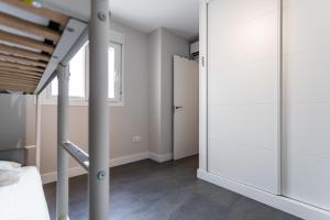 een slaapkamer met witte muren en een bed en een spiegel bij Apt Fuengirola Old Town by Costarentals - Ref 181 in Fuengirola +13 foto's