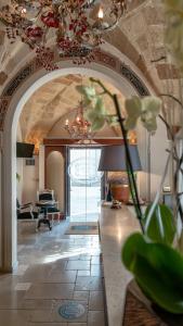 a lobby with an archway with a piano in a room at Kelina Charme Hotel by Cantine Due Palme in Cellino San Marco