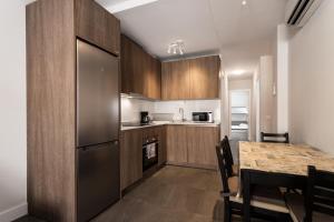 een keuken met een tafel en een roestvrijstalen koelkast bij Apt Fuengirola Old Town by Costarentals - Ref 181 in Fuengirola