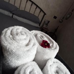 a bed with white towels and a red flower on it at Chiaro di Luna - Casa Vacanze in Rome