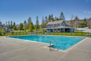 a swimming pool in front of a house at Ski-inandSki-Out Peru Condo with Fire Pit and Grill! in Peru