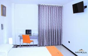 a hotel room with a desk and a bed and a chair at Ivankaa Hostel in Trujillo