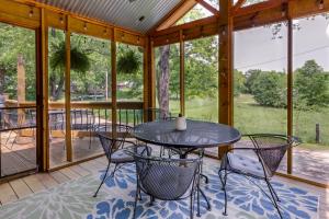 um alpendre com uma mesa e cadeiras em Warsaw Cabin with Sunroom and Lake Access! em Warsaw