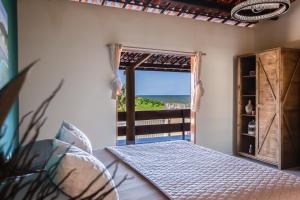a bedroom with a bed and a view of the ocean at Casa Ferreira Cumbuco in Caucaia +121 photos