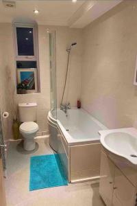 a bathroom with a tub and a toilet and a sink at Stunning seaside studio in Worthing