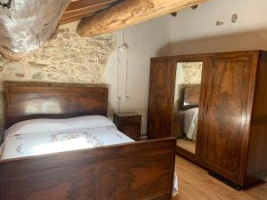 a bedroom with a bed and a mirror at Agriturismo Al Vecio Caselo (Casa Maga) in Arsiero