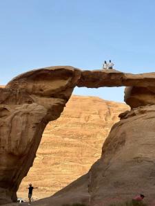 two people standing on a bridge in the desert at Wadi Rum Red Sand Camp in Wadi Rum