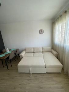 ein weißes Wohnzimmer mit einem Sofa und einem Tisch in der Unterkunft Waterfront Apartments in Durrës