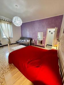 - une chambre avec un lit rouge et un canapé dans l'établissement 'La Casina Di Clara' - Livorno free parking!', à Livourne