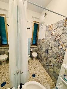 La salle de bains est pourvue de 2 toilettes et d'une douche avec rideau de douche. dans l'établissement 'La Casina Di Clara' - Livorno free parking!', à Livourne