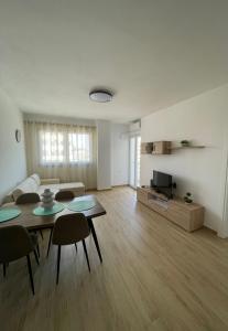 ein Wohnzimmer mit einem Sofa, einem Tisch und Stühlen in der Unterkunft Waterfront Apartments in Durrës