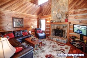 uma sala de estar com um sofá e uma lareira em Kumbaya Log Cabin em Boone
