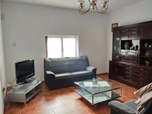 a living room with a couch and a tv at Casa Rural Vega del Tajuña in Armuña de Tajuña