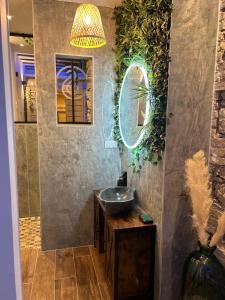 y baño con lavabo y espejo. en Grenoble LA SUITE 2 spa jaccuzzi et sauna privatif en Grenoble