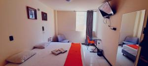 1 dormitorio con cama y alfombra roja en Ivankaa Hostel, en Trujillo