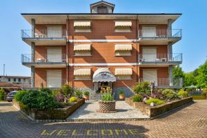 a red brick building with a clock tower at Appartamento Iris in Cisterna dʼAsti