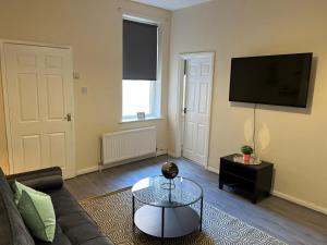 a living room with a couch and a flat screen tv at AA Gateshead in Gateshead