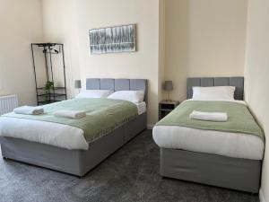 a bedroom with two beds with towels on them at AA Gateshead in Gateshead
