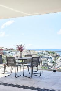 stół i krzesła na balkonie z widokiem na ocean w obiekcie Casa Tamarama w mieście Sydney