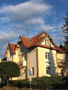un bâtiment d'hôtel avec un toit rouge dans une rue dans l'établissement Hotel Lužná, à Luhačovice