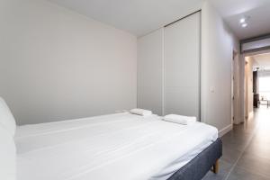 een witte slaapkamer met een groot bed en 2 handdoeken bij Beach Tapas flat in Fuengirola Old Town Ref 182 in Fuengirola