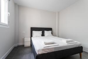 een witte slaapkamer met een bed met een zwart hoofdeinde bij Beach Tapas flat in Fuengirola Old Town Ref 182 in Fuengirola